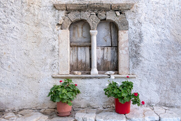 Fototapeta na wymiar Folegandros island, Windows of an old church at Chora town square. Greece, Cyclades.