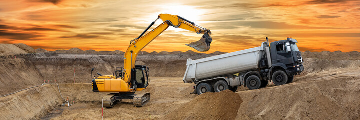excavator working on construction site with dramatic sky © Wolfilser