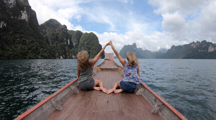Two young woman traveler on longtail boat trip at island hopping in Cheow Lan Lake - Wanderlust and...
