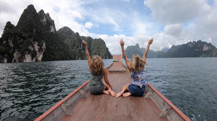 Two young woman traveler on longtail boat trip at island hopping in Cheow Lan Lake - Wanderlust and...