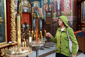 Woman with candle in Saint Nicholas church in Yevpatoria