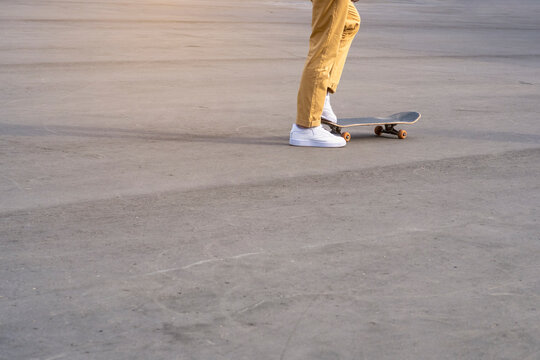 Man legs with skateboard on asphalt. Background image with copy space for text.