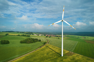 One wind turbine on an agricultural field. Narrow road leading to a village on the swabian alb in...