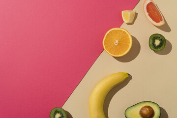 Fresh summer fruit arrangement. Pink and beige background with copy space.