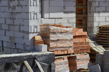 Construction site. Unfinished construction. Building materials. White and red bricks.