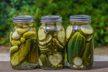 3 Jars of homemade dill pickles outside - Powered by Adobe