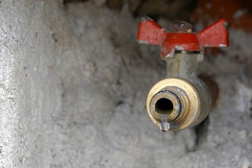 Outdoor hose bib or hydrant  installed in wall. Il is leaking slightly and there is a drop of water...