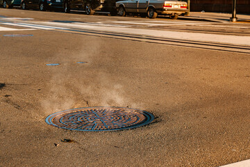 Steam from a manhole on a San Francisco street in the morning - obrazy, fototapety, plakaty