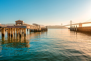 Incredible view of the pier and embankment in San Francisco at sunrise, the Oakland Bay Bridge is visible in the background