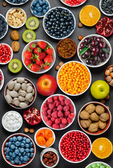 Food for a healthy diet: berries, fruits, nuts, dried fruits. Black concrete background