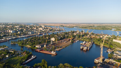 Fototapeta na wymiar Aerial view of the Kherson city. The Dnieper River of which there are cranes and ships. Residential area with houses and greenery