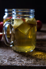 A refreshing jug of apple cider on wood table