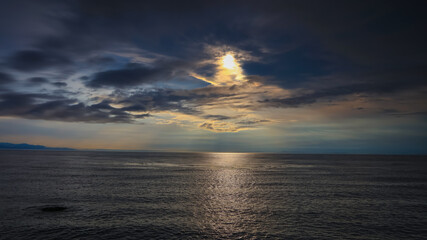 Sunset with dark clouds over Pacific ocean