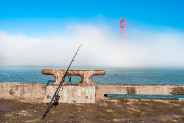 Golden Gate Bridge in the fog, photo taken from the embankment with accessories for fishing, San Francisco