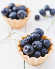 Chokeberry fruit cup cake on a light wooden boards.