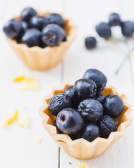 Chokeberry fruit cup cake on a light wooden boards. Top View