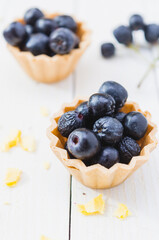 Chokeberry fruit cup cake on a light wooden boards.