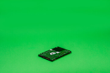 2.5 inch HDD on green background. Mining on hard disk drive concept
