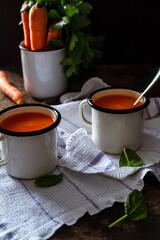 Fototapeta na wymiar Carrot soup on a table in mugs. Homemade healty food