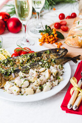 Roasted whole mackerel fish stuffed with vegetables and almonds on wooden table for christmas-top view. Italian Food