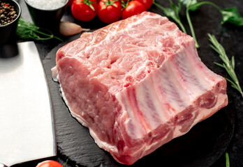 Raw whole pork steaks with ribs on stone background