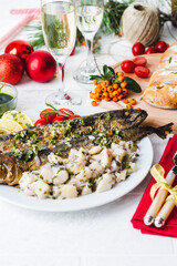 Roasted whole mackerel fish stuffed with vegetables and almonds on wooden table for christmas-top view. Italian Food