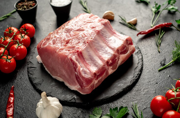 Raw whole pork steaks with ribs on stone background