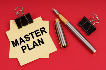 On a red background, a pen and stickers with the inscription - Master Plan