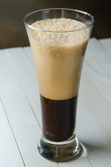  Glass of Latte Macchiato on light wooden boards