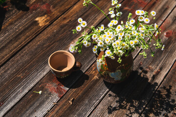 vintage clay jug in which there are wildflowers