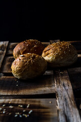 Whole wheat kaiser rolls with sesame seeds on retro crate