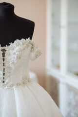 Fototapeta na wymiar The classic white wedding dress decorated with beads with pearls and rhinestones