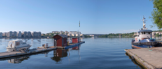 Jetties with tug boat and day cruiser at the lake Mälaren in the district Solna at Stockholm