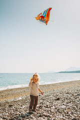 Child girl walking with kite flying on beach summer vacations travel family lifestyle girl kid 2...