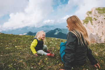 Mother and child daughter outdoor family lifestyle summer vacations together walking in mountains...