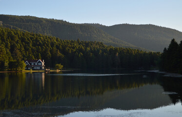 House on the lake in Bolu Gölcük National Park, reflection of trees and  house on lake