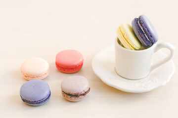 Different coloured macarons in tea cup. Selective Focus