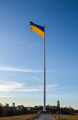 The highest flagpole with Ukrainian flag waving in blue sky in Kyiv, Ukraine