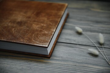 Luxury wooden photo book on natural background. Family memories photobook. Save your summer vacation memories. Photo album wedding photoalbum with wooden cover.