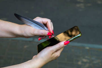 Woman tries to use a bird pen for smartphone.