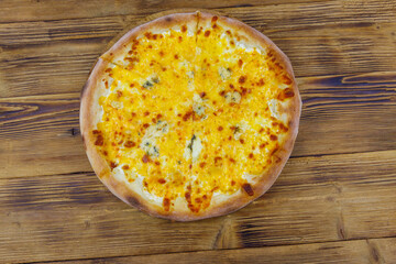 Pizza Four cheese on a wooden background. Top view