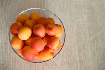 Top view of fresh ripe apricots in bowl with copy space