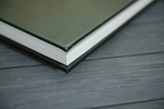Green wedding or family photo book with leather cover. stylish wedding photo album close up. family photoalbum on wooden background.