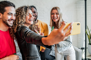 Group of friends taking a selfie with a mobile phone.