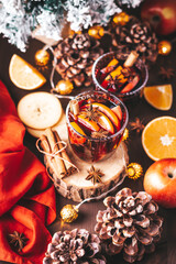 Mulled wine on table with Christmas lights and red napkin, cozy winter still life. Winter lifestyle at home, winter drink closeup, warm atmosphere