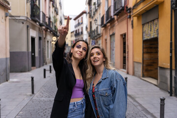 Two girls smiling and looking around while having a walk in the city center