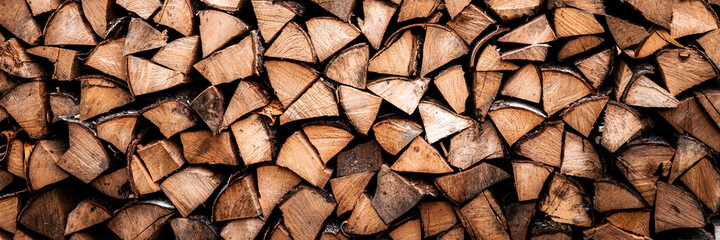 Strukturierter Brennholzhintergrund aus gehacktem Holz zum Anzünden und Heizen des Hauses. ein Holzstapel mit gestapeltem Brennholz. die Textur der Birke. Banner