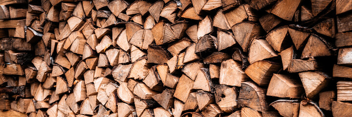 textured firewood background of chopped wood for kindling and heating the house. a woodpile with stacked firewood. the texture of the birch tree. banner