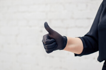 Obraz premium An image of a girl's hands putting on a black latex glove