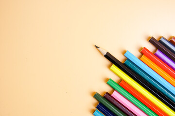 Color pencils on orange background, copy space